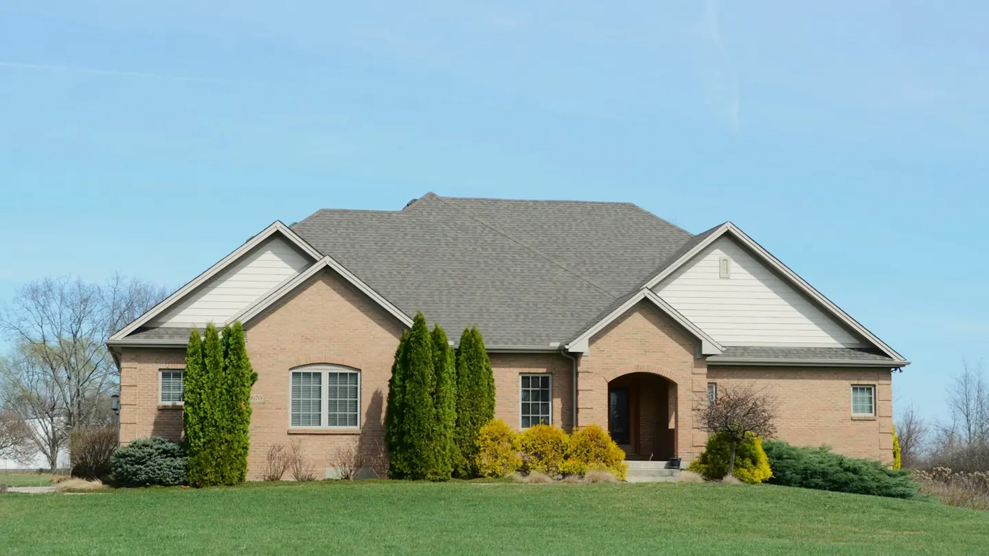 Brick residential house exterior with a maintained lawn